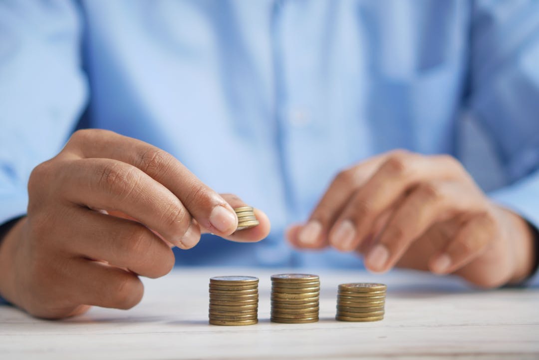 two hands stacking coins