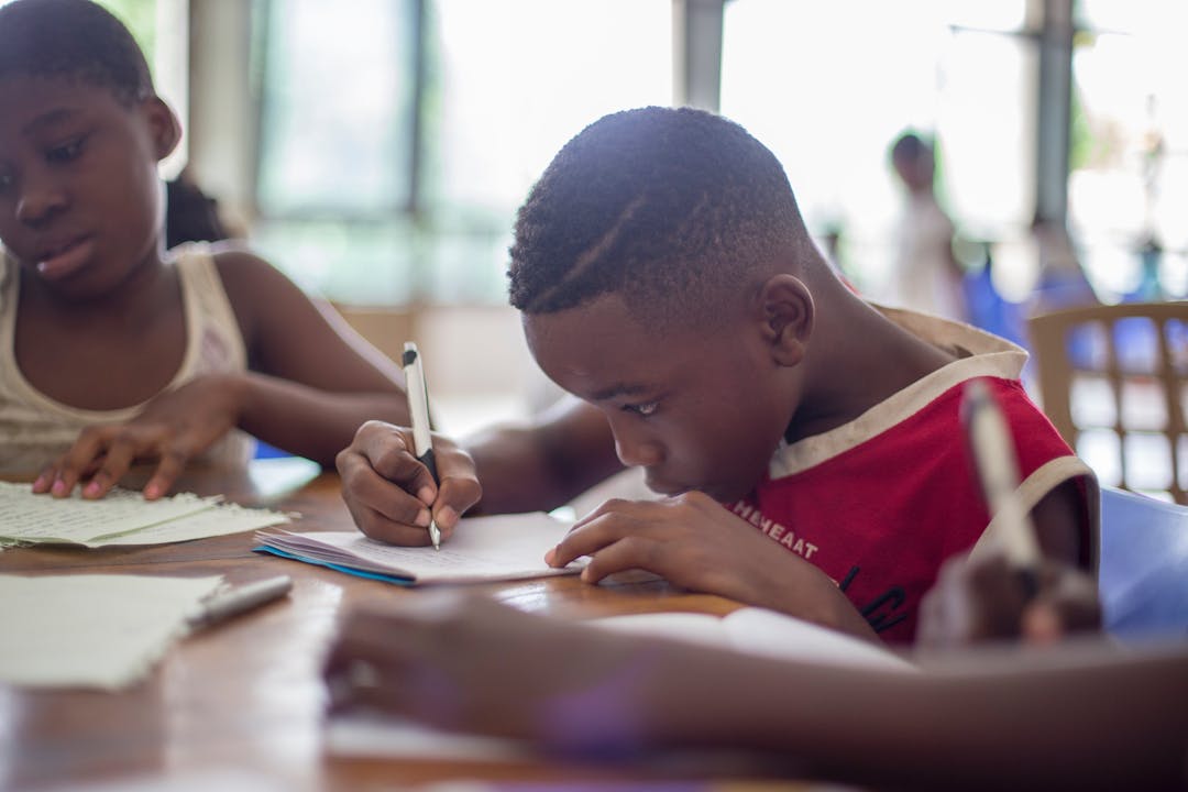 a boy writing on a notebook