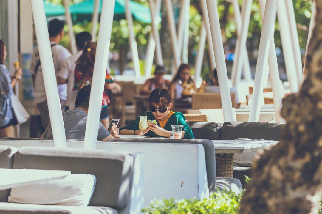 people eating outside while on their phone