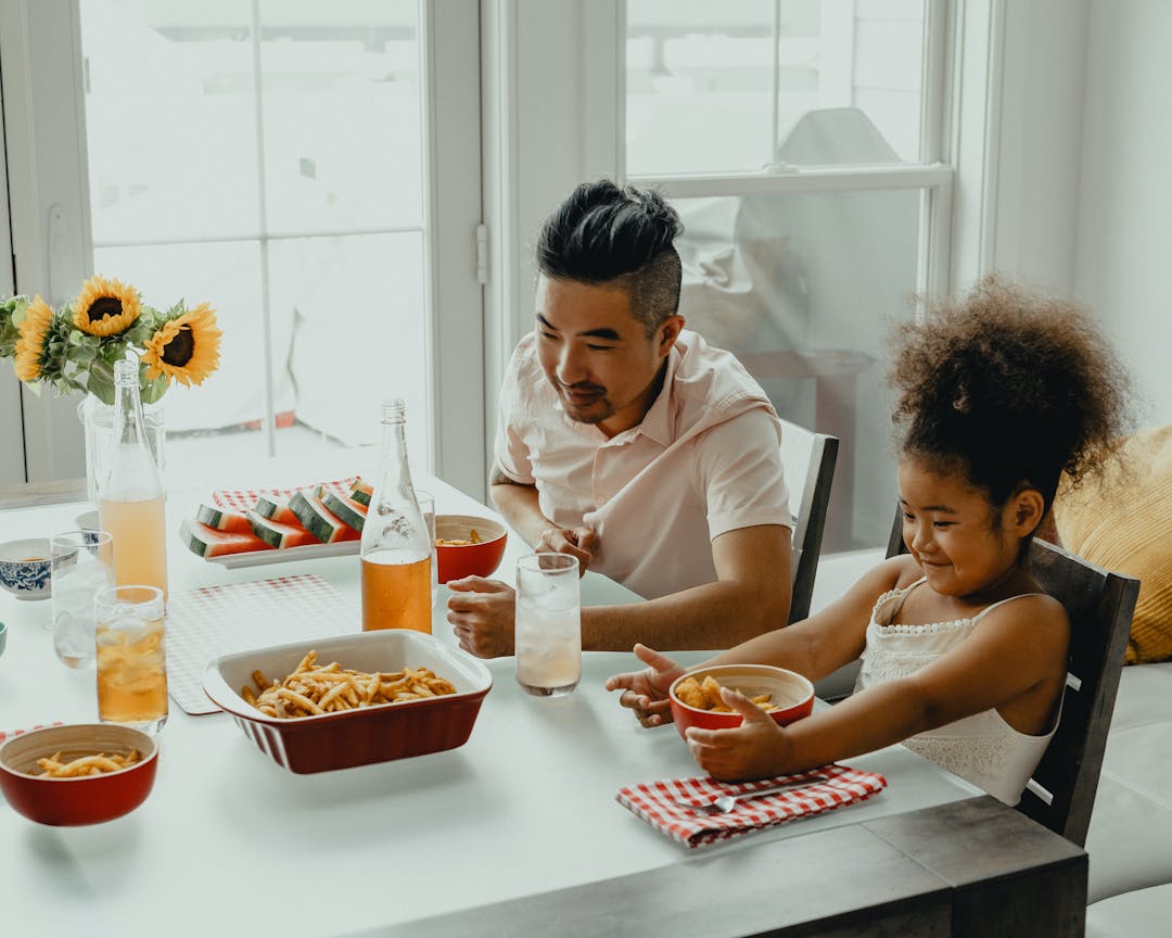 father and daughter eating french fries together