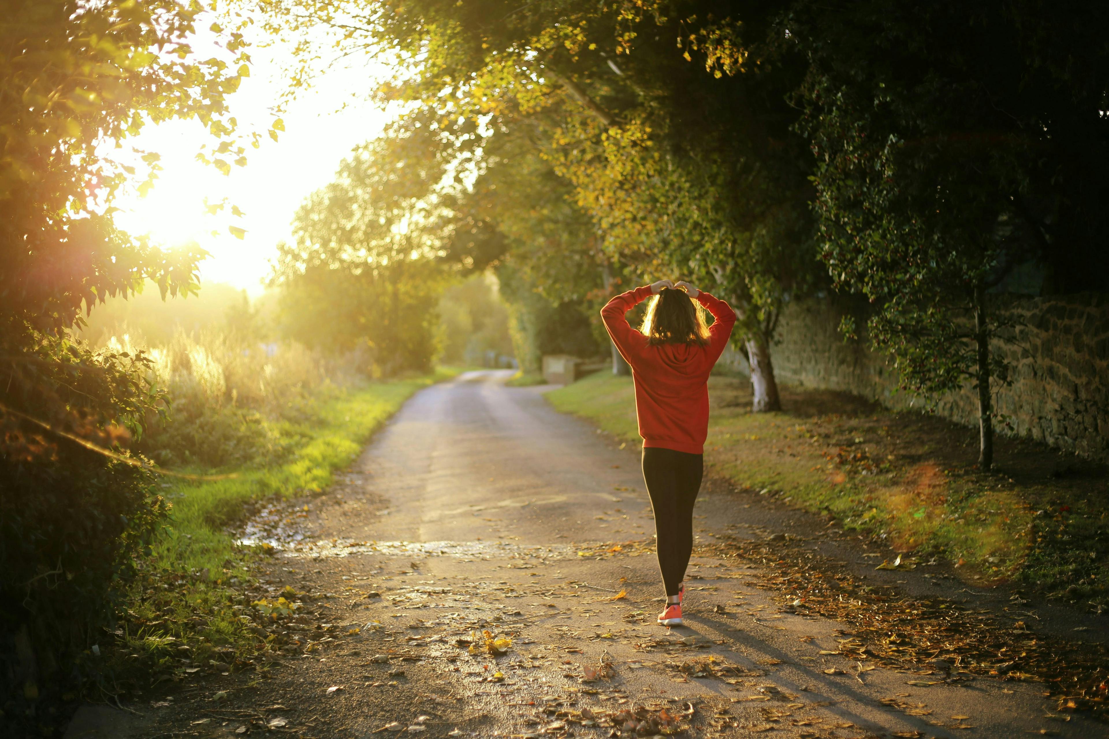 girl wearing a red hoodie walking on the street