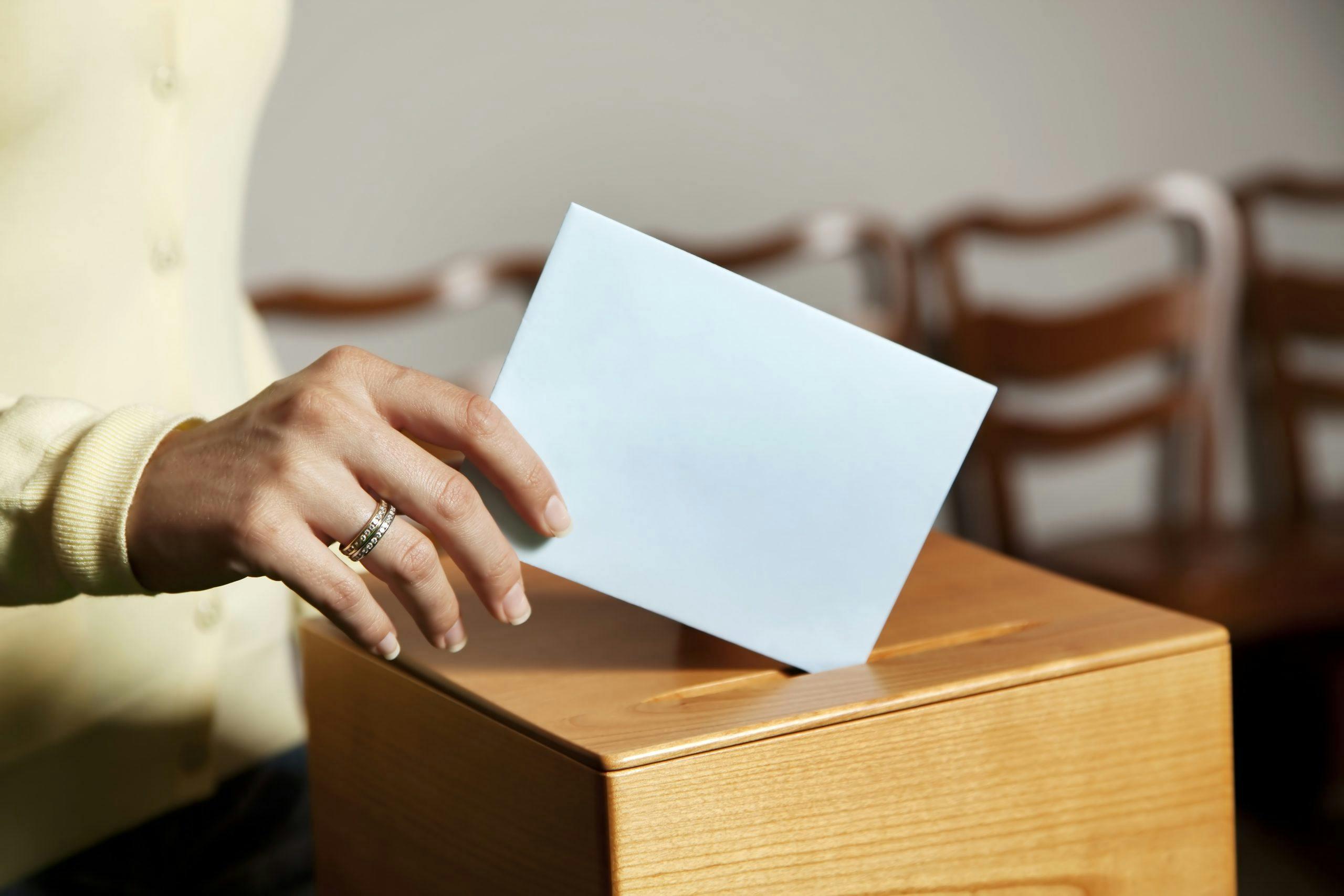 a young woman with a voter in the voting booth. voting in a democracy